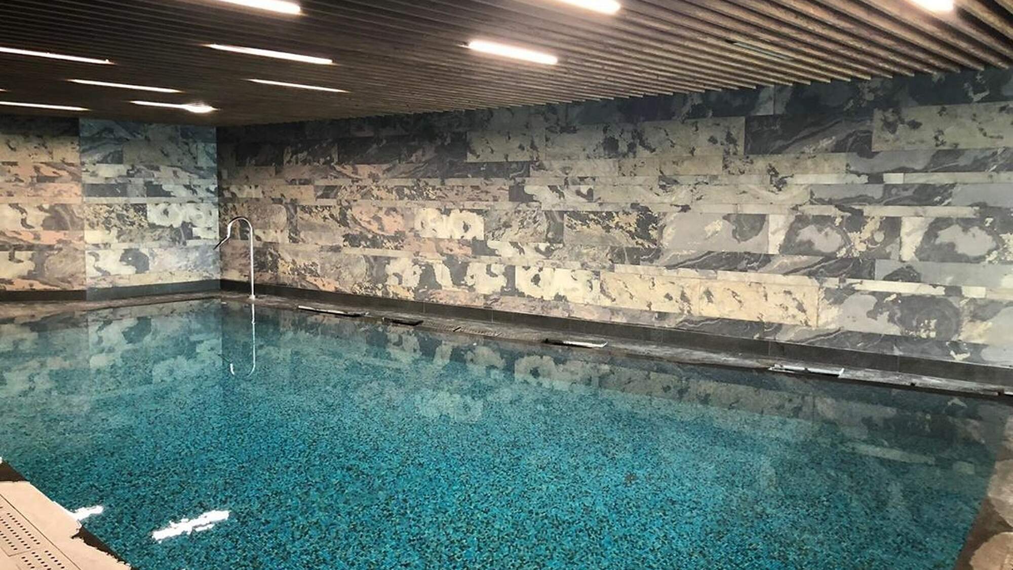 Sliced stone feature wall beside an indoor pool